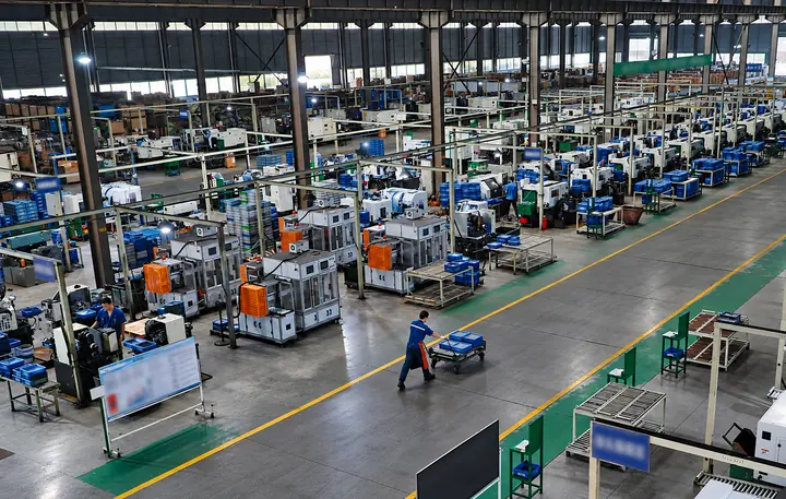 Automotive component factory with production equipment and organized workstations